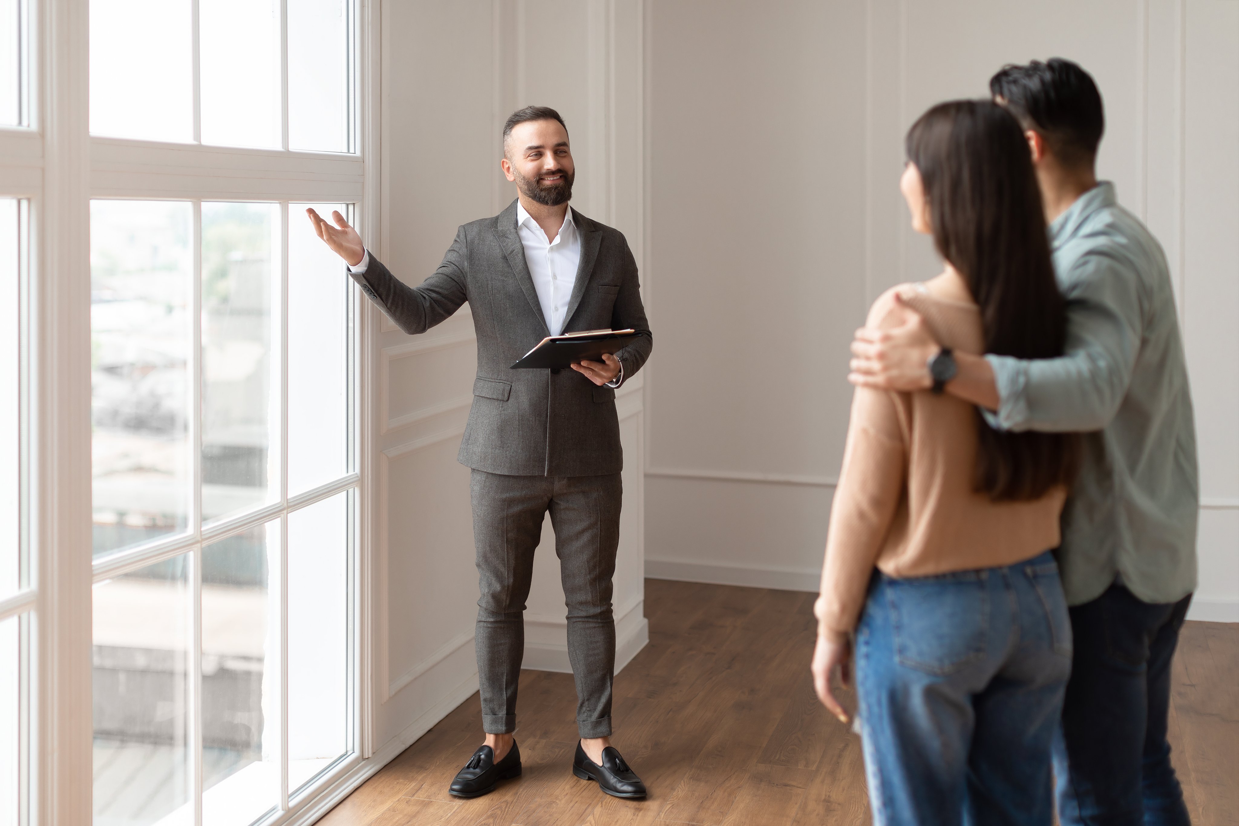 Real estate agent explaining figures to a couple during a home tour