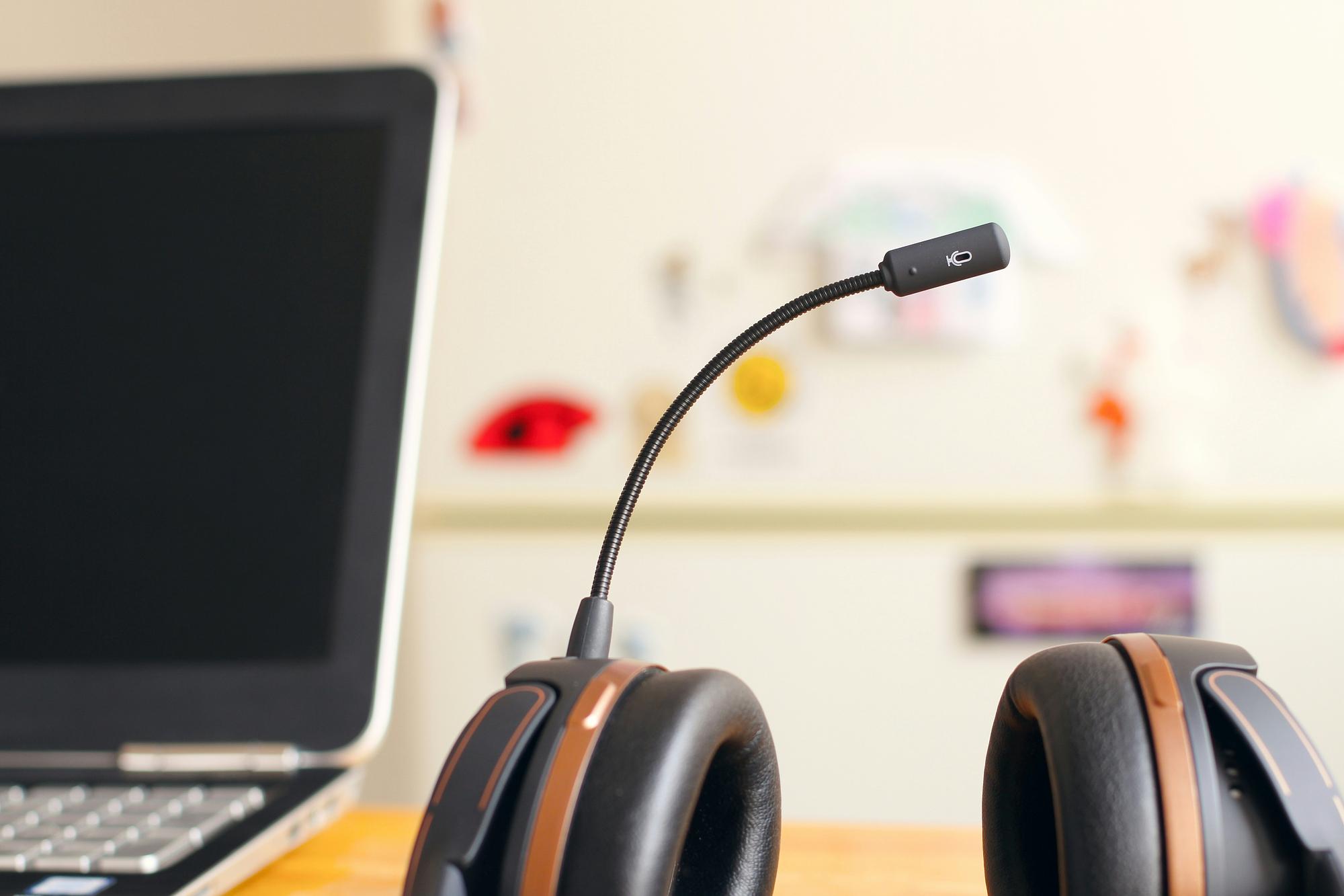 A headset resting beside a laptop on a desk, evoking the voice-support work that AI helps clear from the queue.