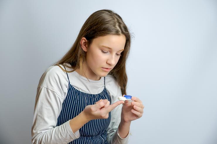 a kid trying to wear contact lenses