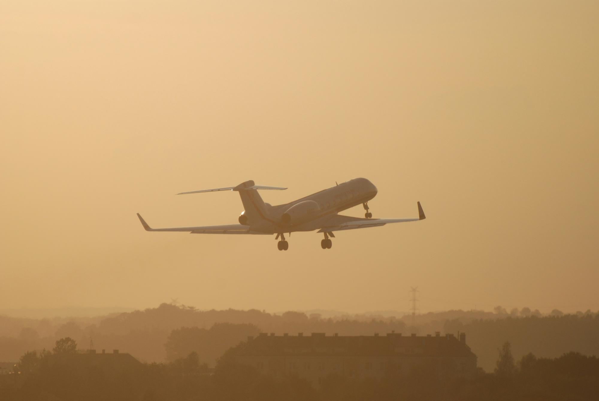 Gulfstream ultra-long-range business jet climbing into a sunset sky