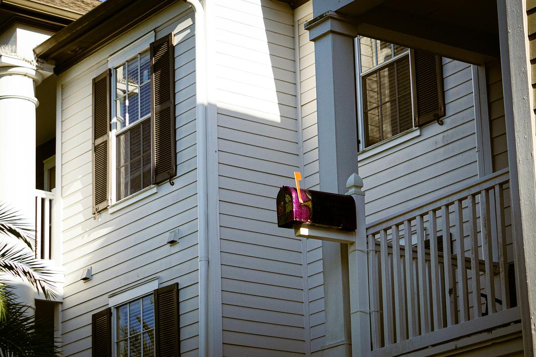 A mailbox in front of a suburban home, where real estate direct-mail postcards land