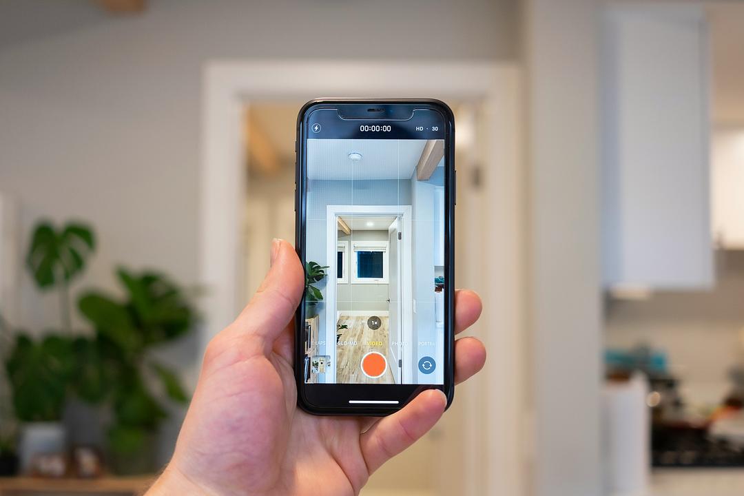 Real estate agent recording a smartphone video tour of an apartment